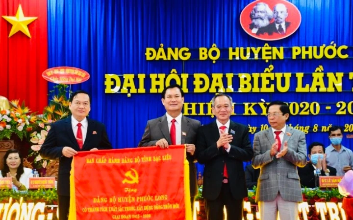 Đồng chí Lữ Văn Hùng, Bí thư Tỉnh ủy (thứ hai từ phải sang) trao Cờ của Ban Chấp hành Đảng bộ tỉnh cho Đảng bộ huyện Phước Long, vì có thành tích xuất sắc trong xây dựng nông thôn mới.