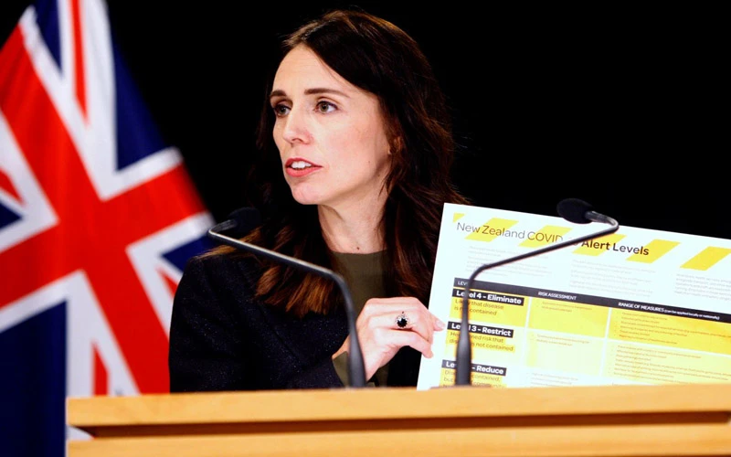 Thủ tướng New Zealand Ardern cầm bảng giới thiệu hệ thống cảnh báo Covid-19 mới tại Wellington, ngày 21-3. (Ảnh: AP)