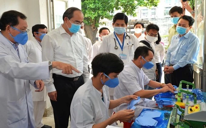 Đồng chí Nguyễn Thiện Nhân thăm nơi sản xuất khẩu trang của Bệnh viện Thống Nhất. (Ảnh: Báo SGGP)