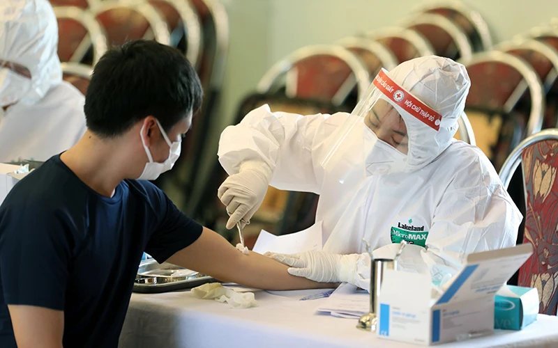 Lực lượng y tế phường Dịch Vọng, quận Cầu Giấy (Hà Nội) lấy mẫu xét nghiệm nhanh Covid-19 với các công dân đi từ TP Ðà Nẵng về địa bàn. Ảnh: NGỌC CHÂU 