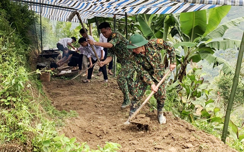 Cán bộ, chiến sĩ Ðồn Biên phòng Thàng Tín (Hà Giang) san nền, dựng lán tạm cho gia đình nạn nhân bị thiệt hại do lở đất. Ảnh: ÐÌNH TRỌNG