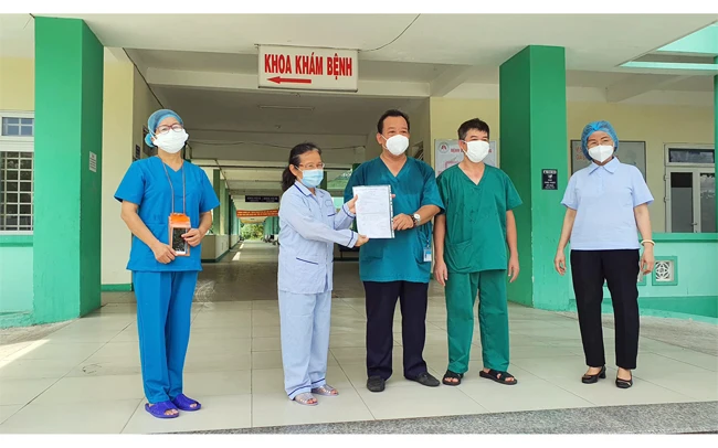 Giám đốc Bệnh viện Phổi Đà Nẵng công bố và trao giấy chứng nhận khỏi bệnh cho người bệnh Covid-19. Ảnh: MINH THÙY