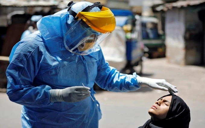 Nhân viên y tế lấy mẫu xét nghiệm Covid-19 cho người dân tại Ahmedabad, Ấn Độ, ngày 8-4. (Ảnh: Reuters).