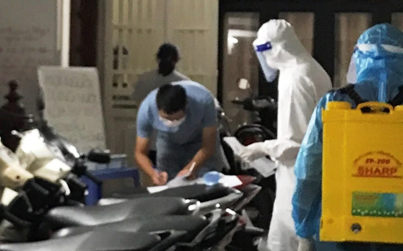 Đội phản ứng nhanh của Trung tâm Y tế quận Thanh Xuân phun khử trùng nơi có ca dương tính với SARS-CoV-2. (Ảnh: Báo KTĐT)