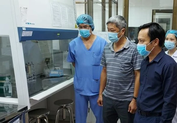 Thứ trưởng Nguyễn Trường Sơn (giữa) và TS Hoàng Quốc Cường (phải) kiểm tra quy trình vận hành của phòng xét nghiệm mà Viện Pasteur TPHCM lắp đặt tại Bệnh viện C Đà Nẵng.