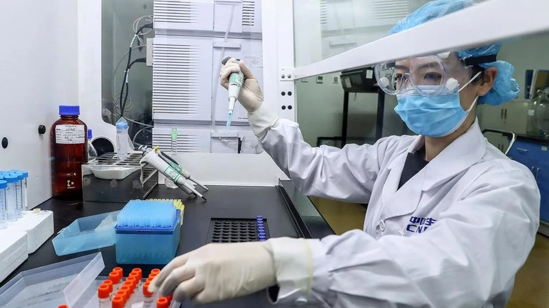 Một nhân viên đang thử nghiệm các mẫu vaccine Covid-19 tiềm năng tại nhà máy sản xuất của Sinopharm ở Bắc Kinh, Trung Quốc ngày 11-4. Ảnh: Tân Hoa xã.