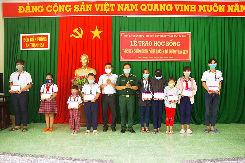 Đại diện Ban Chỉ huy Đồn Biên phòng An Thạnh Ba và lãnh đạo Chi nhánh Viettel Sóc Trăng trao học bổng cho các em học sinh. 