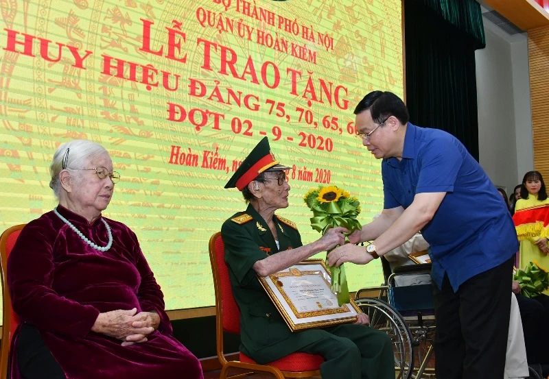 Ủy viên Bộ Chính trị, Bí thư Thành ủy Vương Đình Huệ trao Huy hiệu 75 năm tuổi Đảng các đồng chí đảng viên. (Ảnh: DUY LINH)