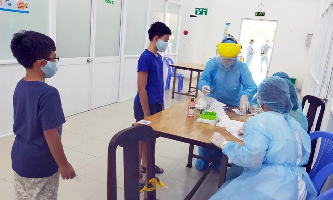 Lấy mẫu xét nghiệm Covid-19 cho người dân tại Trung tâm Y tế quận Tân Bình.