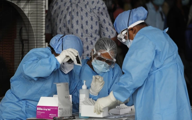 Nhân viên y tế chuẩn bị làm xét nghiệm tìm kháng nguyên virus SARS-CoV-2 cho lao động nhập cư tại New Delhi, Ấn Độ, ngày 18-8. (Ảnh: AP)