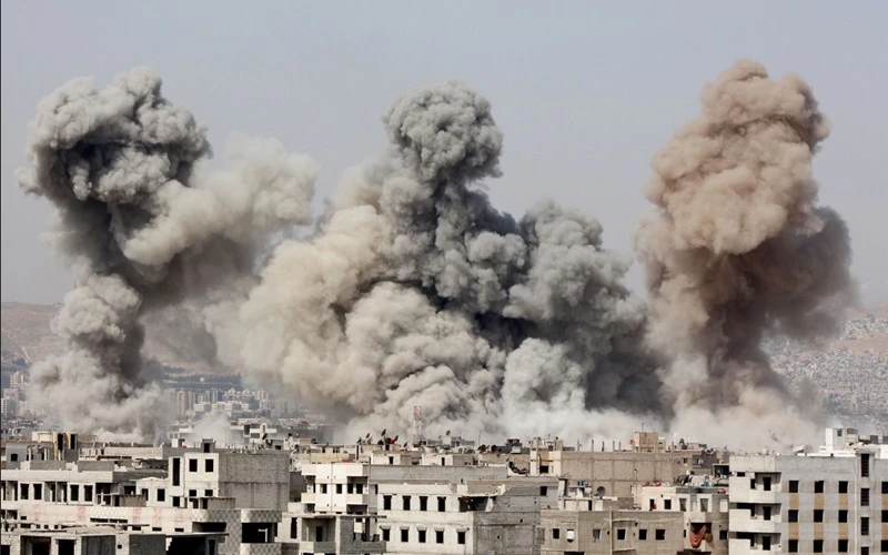 Khói bốc lên từ khu vực ngoại ô phía đông Damascus sau cuộc không kích diễn ra vào tháng 3-2015. Nhiều khu vực tại Syria đã bị tàn phá trong một thập kỷ giao tranh. (Ảnh: Reuters) 