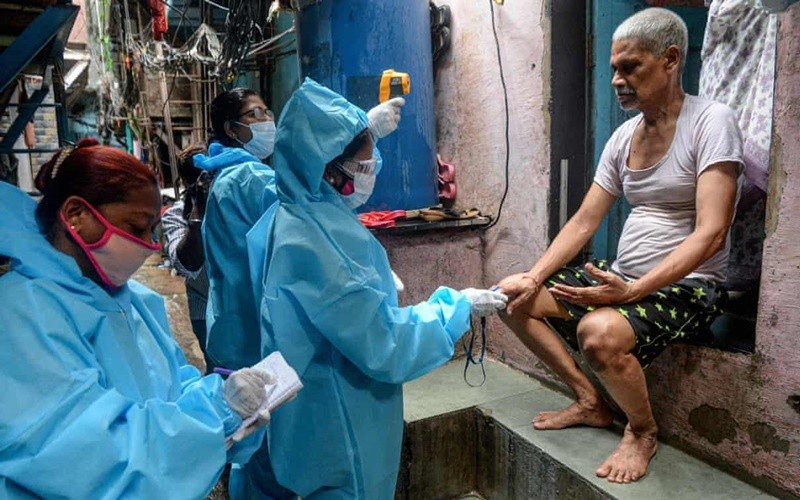 Nhân viên y tế đo thân nhiệt của người dân sống trong khu ổ chuột Dharavi, tại Mumbai. (Ảnh: Getty Images)