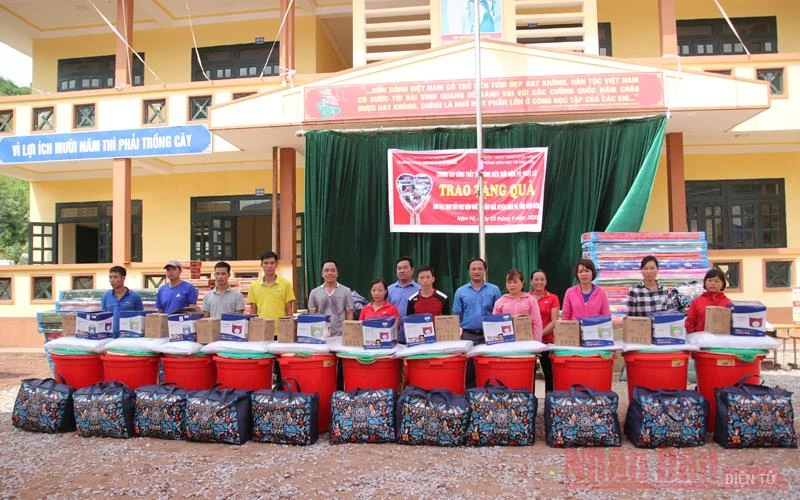 Đại diện Báo Giáo dục -Thời đại và lãnh đạo huyện Nậm Pồ trao quà cho giáo viên, học sinh bị ảnh hưởng bởi thiên tai.