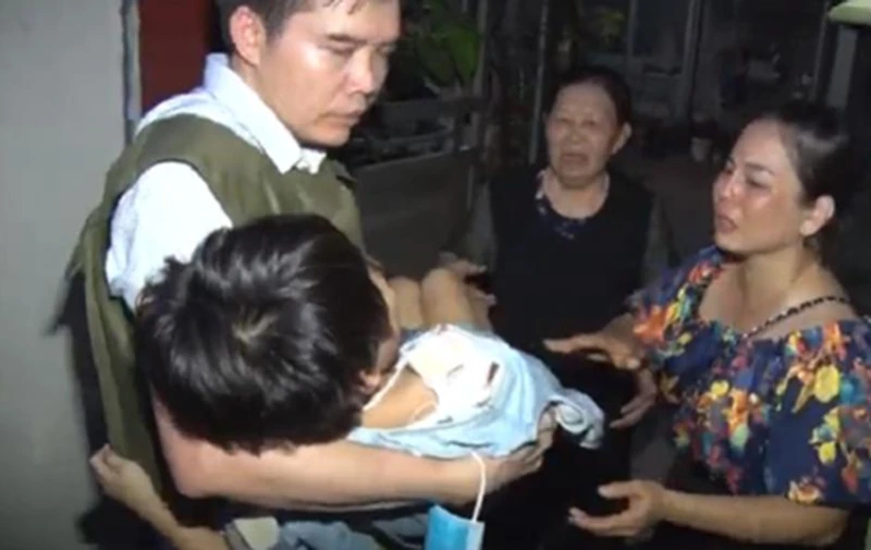 Lực lượng chức năng giải cứu bé gái bị bố đẻ bạo hành. (Ảnh: congan.com.vn)