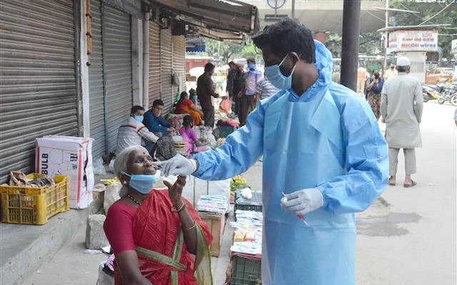 Nhân viên y tế lấy mẫu dịch xét nghiệm Covid-19 cho người dân tại một khu chợ ở Bangalore, Ấn Độ ngày 30-8-2020. (Ảnh: THX/TTXVN)