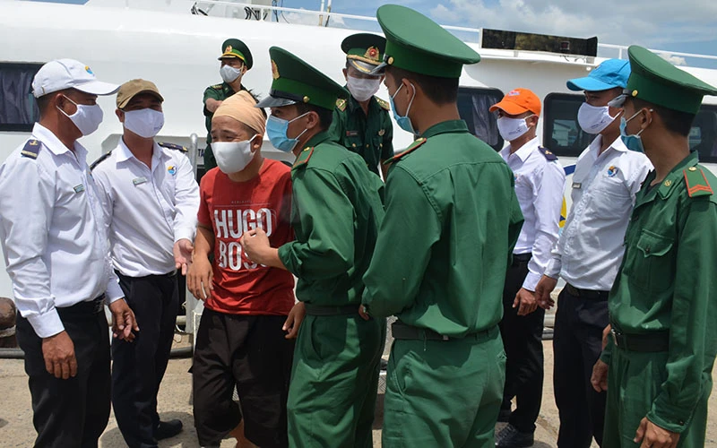 Cán bộ, chiến sĩ Bộ đội Biên phòng tỉnh Bình Thuận đón các ngư dân bị nạn được đưa từ Phú Quý vào đất liền ngay sau khi tàu cập cảng Phan Thiết.