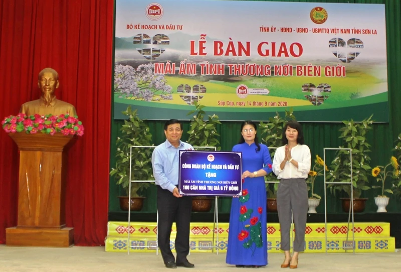 Đồng chí Nguyễn Chí Dũng trao tặng biển hỗ trợ 100 căn nhà cho huyện Sốp Cộp. 