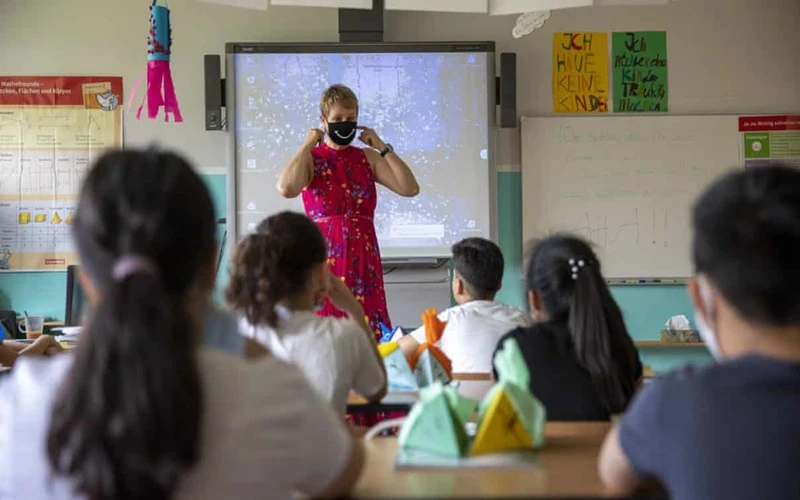 Giáo viên đeo khẩu trang khi giảng giải về chủng virus corona mới tại một lớp học ở Berlin, Đức. (Ảnh: Getty Images)