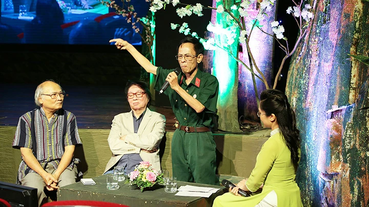 Nhà thơ Hoàng Nhuận Cầm (đứng) đọc thơ trong một chương trình văn nghệ.