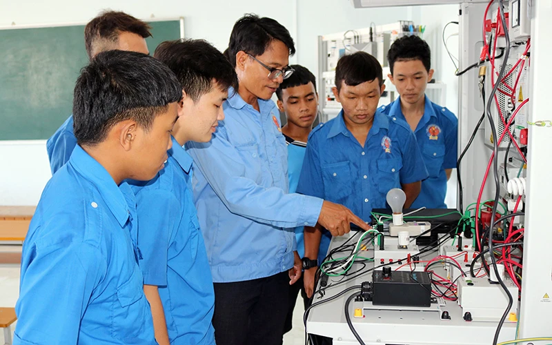 Học viên Trường cao đẳng nghề Ninh Thuận thực hành mô hình hệ thống chuyển đổi năng lượng điện gió. Ảnh: NGUYỄN THÀNH (TTXVN) 
