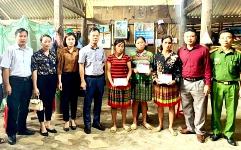Lãnh đạo huyện ủy Văn Bàn và đoàn công tác trao sổ tiết kiệm cho gia đình nạn nhân vụ sập cổng trường học ở địa phương. 