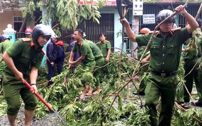 Công an tỉnh Thừa Thiên Huế cùng các đơn vị chức năng dọn dẹp cây xanh ngã đổ do bão số 5 gây ra trên địa bàn. Ảnh: CÔNG HẬU