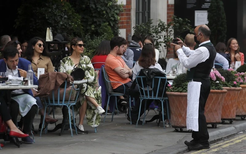 Từ ngày 24-9, tất cả nhà hàng, khách sạn, quán rượu tại Anh chỉ được phục vụ khách dùng bữa tại bàn. (Ảnh: Reuters)