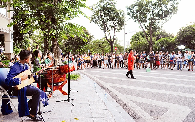 Người dân xem biểu diễn nghệ thuật tại phố đi bộ Hồ Gươm ngày cuối tuần. Ảnh | ANH ĐỨC