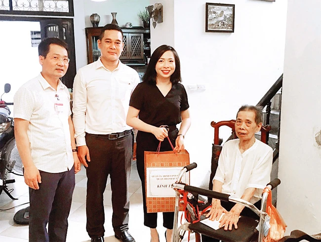 Trưởng ban Dân vận Quận ủy Thanh Xuân Bùi Thu Trang (thứ hai từ phải sang) thăm, tặng quà gia đình chính sách tại phường Phương Liệt. Ảnh: MAI THANH