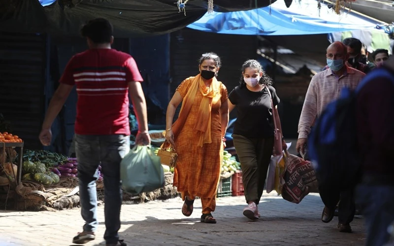 Người dân đeo khẩu trang khi đi trong khu chợ tại Jammu, Ấn Độ, ngày 23-9. (Ảnh: AP)