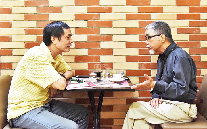 Nhà văn Trung Trung Đỉnh (phải) trò chuyện với nhà thơ Hữu Việt. Ảnh: TRẦN HẢI