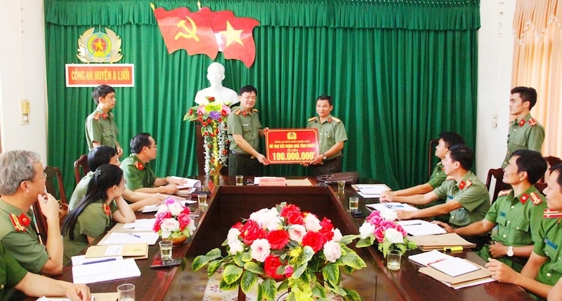 Thượng tá Nguyễn Thanh Tuấn trao số tiền 100 triệu đồng để hỗ trợ xây dựng nhà tình nghĩa cho cán bộ Công an huyện A Lưới có hoàn cảnh khó khăn.