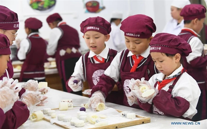 Học sinh của Trường tiểu học Huaguoyuan 3, tại tỉnh Quý Châu, tây nam Trung Quốc hào hứng làm bánh Trung thu. (Ảnh: Tân Hoa xã)