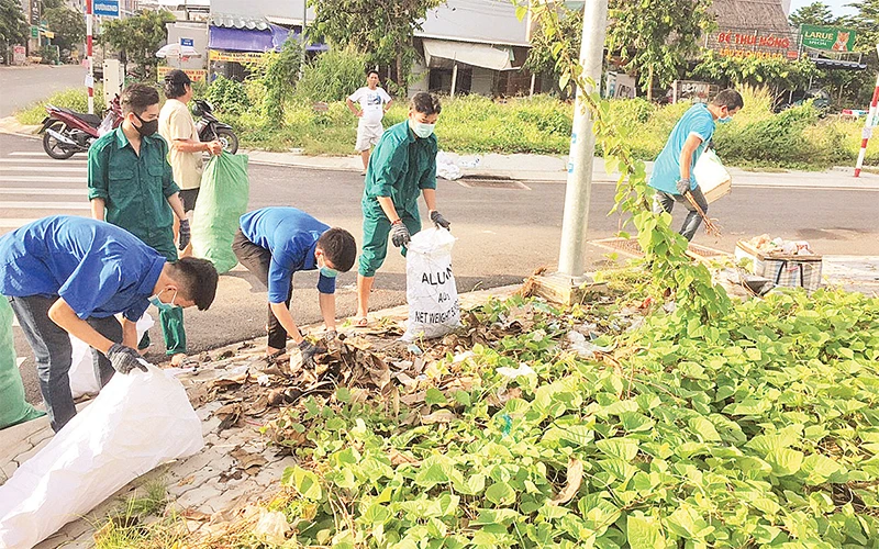 Ðoàn viên, thanh niên cùng người dân khu phố 4, phường Tăng Nhơn Phú A (quận 9) dọn dẹp vệ sinh đường phố.