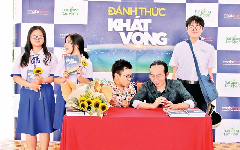 Diễn giả Nguyễn Sơn Lâm (ngồi giữa) và Nhạc sĩ Hà Chương ký tặng sách cho học sinh Trường THPT Gò Vấp, TP Hồ Chí Minh tại chương trình "Ðánh thức khát vọng".