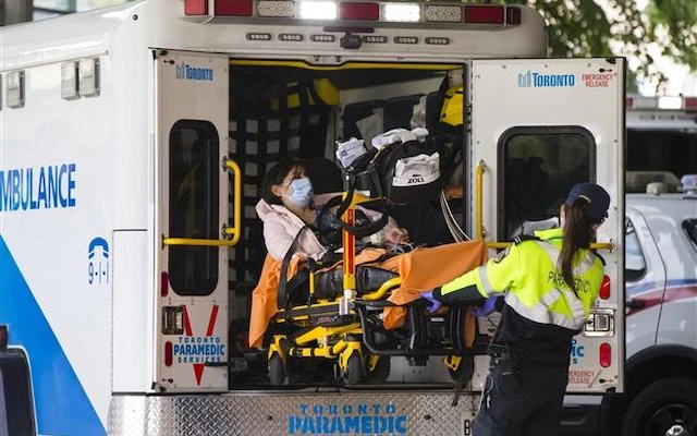  Nhân viên y tế chuyển bệnh nhân Covid-19 tới bệnh viện tại Toronto, Canada, ngày 17-9-2020. (Ảnh: THX/TTXVN)