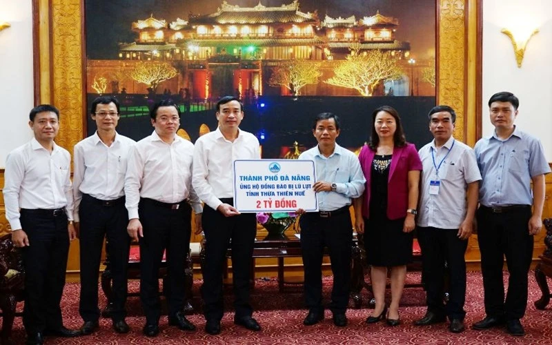 Lãnh đạo TP Đà Nẵng (bên trái) trao số tiền hai tỷ đồng đến lãnh đạo tỉnh Thừa Thiên Huế. 