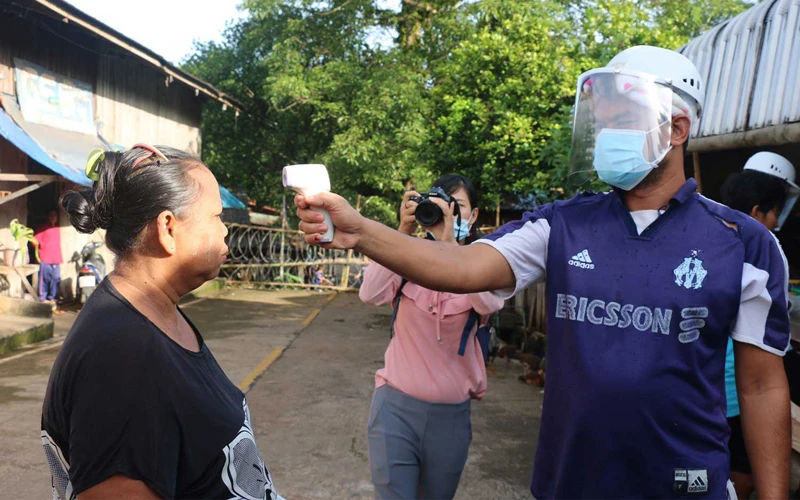 Nhân viên y tế Thái Lan tiến hành đo thân nhiệt của một người dân ở tỉnh Kanchanaburi - nơi tiếp giáp biên giới với Myanmar (Ảnh Bangkok Post)