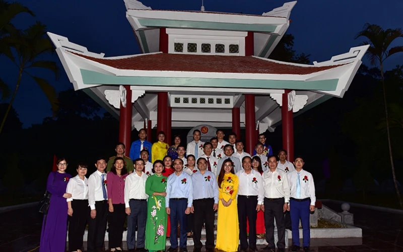 Các đồng chí đại biểu chụp ảnh lưu niệm tại Nhà bia kỷ niệm nơi làm việc của Ban Tổ chức Trung ương, tại thôn Tân Lập, xã Tân Trào, huyện Sơn Dương, tỉnh Tuyên Quang.