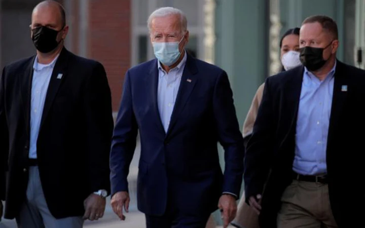 Ứng cử viên Tổng thống Mỹ Joe Biden (đứng giữa) có kết quả âm tính với virus SARS-CoV-2 ở lần xét nghiệm thứ hai. Ảnh: Reuters