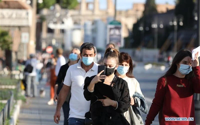 Người dân đeo khẩu trang đi bộ trên đường Via dei Fori Imperiali, ở Rome, Italy, ngày 6-10-2020. (Ảnh: Xinhua)