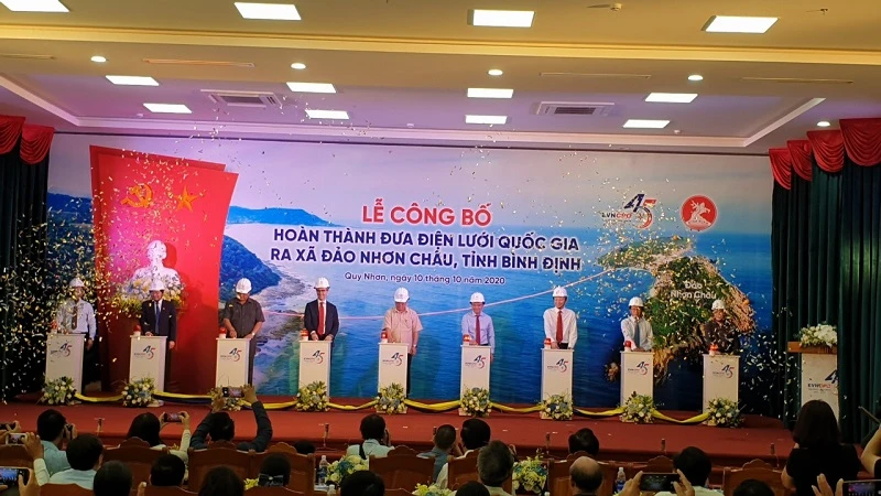 Các đại biểu thực hiện nghi thức đóng điện dự án đưa điện lưới Quốc gia ra xã đảo Nhơn Châu, thành phố Quy Nhơn.