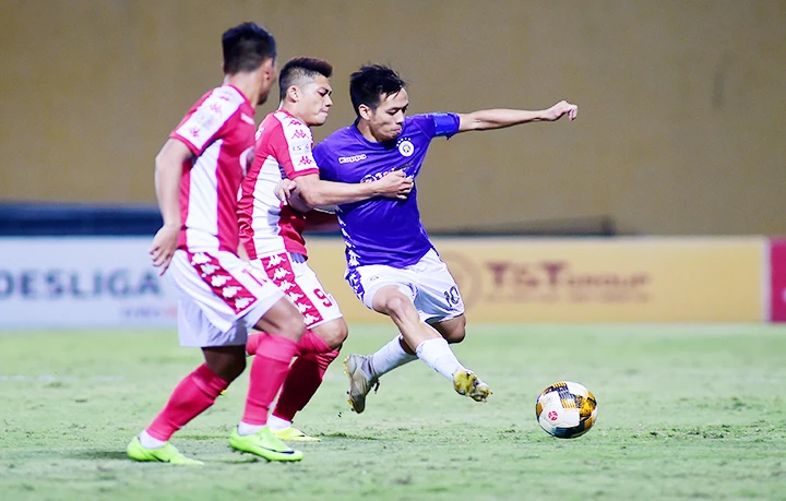 Pha tranh bóng của cầu thủ Văn Quyết (số 10) đội Hà Nội FC và các cầu thủ đội TP Hồ Chí Minh. Ảnh: TRẦN ĐỨC