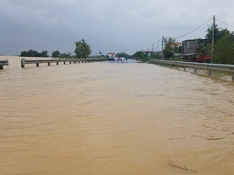 Trưa 10-10, Quốc lộ 1A qua huyện Quảng Ninh (Quảng Bình) vẫn còn ngập. Ảnh: HƯƠNG GIANG.