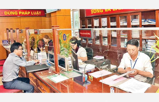 Giải quyết thủ tục hành chính cho người dân tại Bộ phận một cửa UBND quận Thanh Xuân. Ảnh: DUY LINH