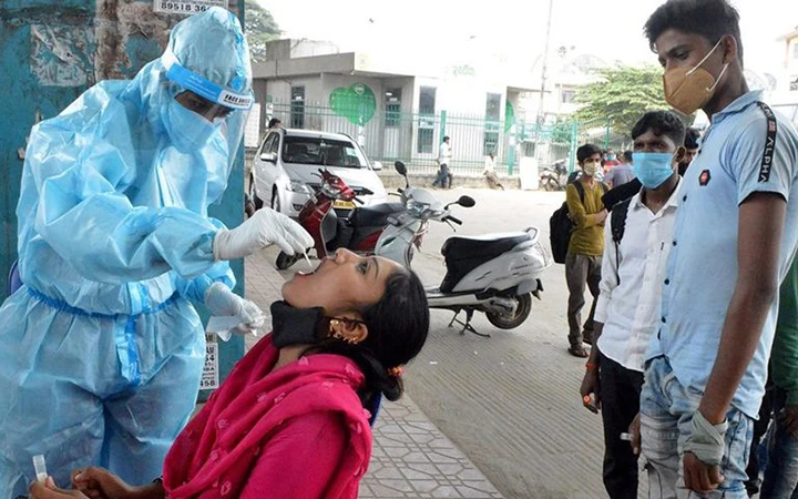 Nhân viên y tế lấy mẫu xét nghiệm Covid-19 cho người dân ở khu vực Băng-ga-lo của Ấn Độ. Ảnh Tân Hoa xã