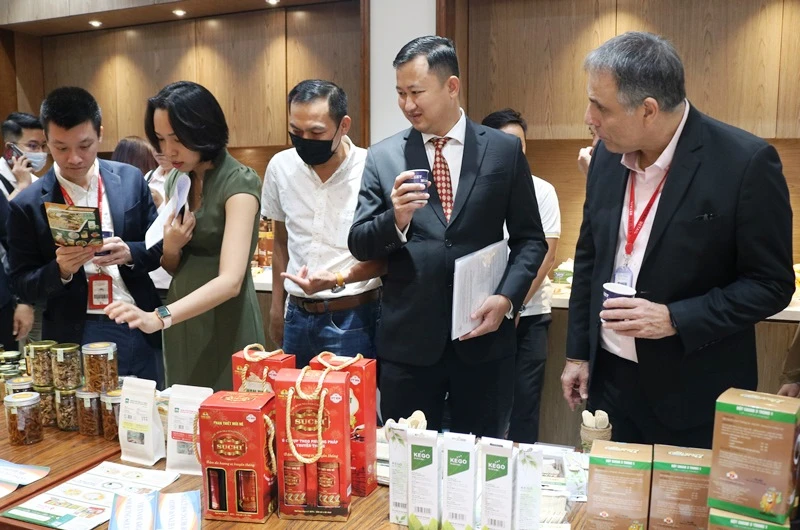 Các đại biểu tham quan gian hàng trưng bày sản phẩm của doanh nghiệp trong nước tại hội nghị.