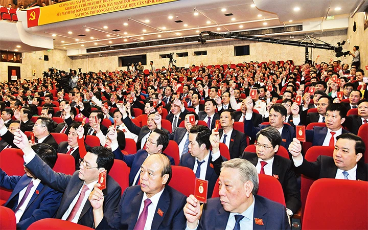 Các đại biểu biểu quyết thông qua Nghị quyết Đại hội Đảng bộ thành phố Hà Nội lần thứ 17. Ảnh: VŨ LINH