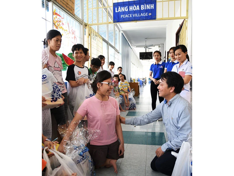 Phó Bí thư Đảng ủy, Tổng Giám đốc Saigon Co.op Nguyễn Anh Đức trao quà cho trẻ em khuyết tật ở Làng Hòa Bình.