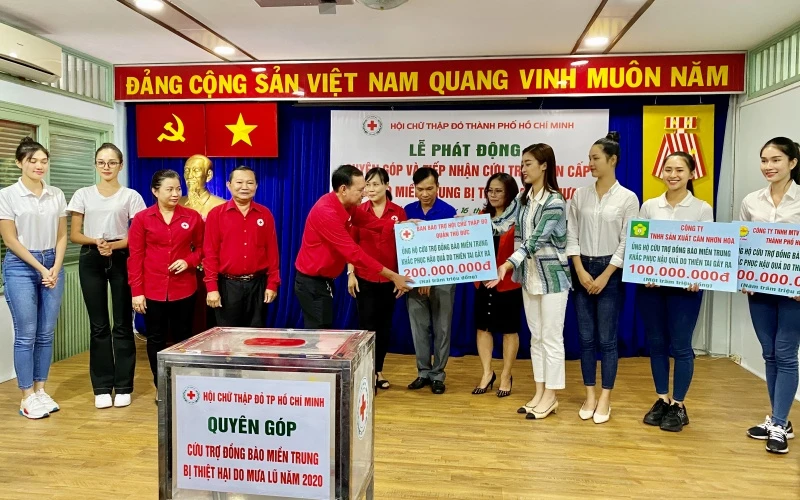 Các thí sinh tham dự Cuộc thi Hoa hậu Việt Nam là tình nguyện viên, cùng lãnh đạo Hội CTĐ TP Hồ Chí Minh tiếp nhận bảng biểu trưng đóng góp ủng hộ của các đơn vị.